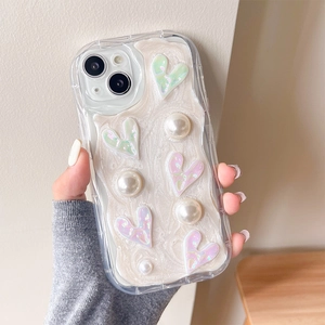 Détail d'une coque iPhone texturée crème avec cœurs irisés et perles blanches factices