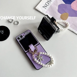 Detail of purple faux leather Z Flip case with pearl strap and diamond bear charm
