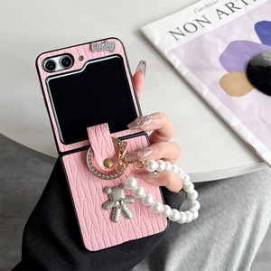 Detail of pink pleated leather phone case for Samsung Z Flip with pearl strap and bear charm