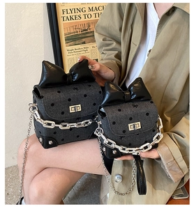 Detailed comparison of large and small polka dot denim handbags with bow and chain straps