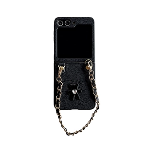 Black leather folding phone case with gold chain strap and heart rhinestone bear