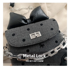 Close-up of the silver square metal buckle and herringbone fabric on the mini crossbody bag