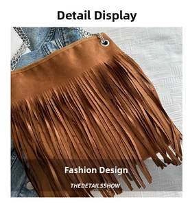 Détail d'un sac à bandoulière en daim marron avec franges et chaîne en métal argenté
