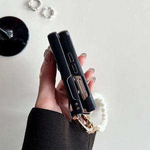 Detail of Z Flip5 black leather case with luxury pearl wrist strap and precise button cutouts