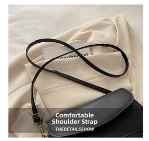 Close-up of sleek black square shoulder bag with gold metal hooks on a beige blazer