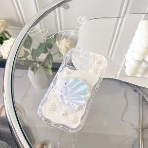 Detail of glitter shell phone case with white pearls and snowflakes for iPhone 15