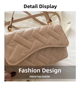 Detail of beige faux leather handbag featuring modern quilted woven texture and gold ring