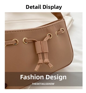 Detail of light brown leather shoulder bag featuring drawstring design and gold eyelets