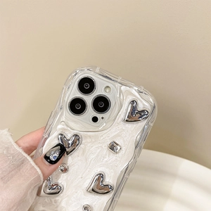 Macro detail of silver 3D hearts and rhinestones on cream textured iPhone case