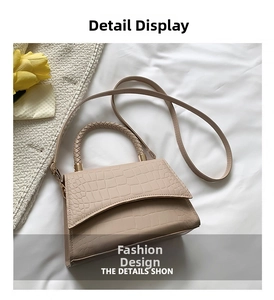 Detail of apricot crocodile pattern bag with woven handle and elegant gold-tone hardware