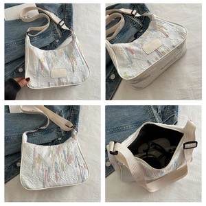 Detail view of white embroidered tote bag with color stripes and texture patterns