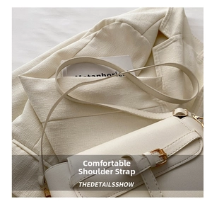 Detail of adjustable slim shoulder strap and metal buckle on cream crossbody square bag