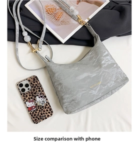 Detailed size comparison of a gray textured tote bag with a gold metal strap next to a phone