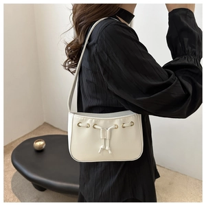 Detail of white PU leather shoulder bag with drawstring design and gold eyelets