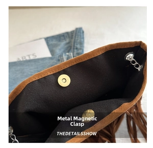 Détail du fermoir magnétique et de la chaîne sur le sac seau en daim marron à franges
