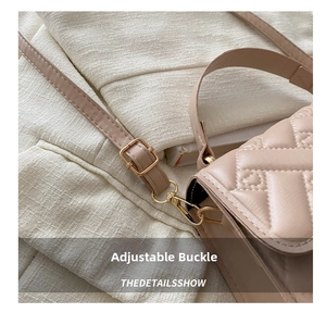 Close-up of adjustable metal buckle and hook detail on a beige quilted leather handbag