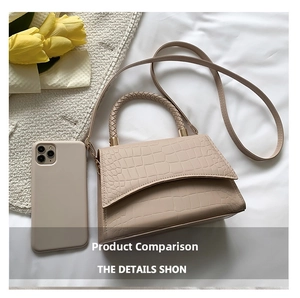 Detail of beige crocodile pattern bag with braided handle and phone for size comparison