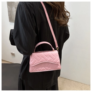 Close-up of pink quilted crossbody bag with textured faux weave and top handle design