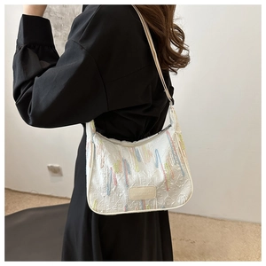 Detail of white shoulder bag featuring colored embroidery and JINGPINPIJU logo