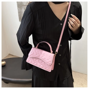Detailed view of pink mini crossbody bag with embossed monogram and slim shoulder strap