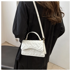 Quilted white crossbody bag with heart texture shown on model for size perspective