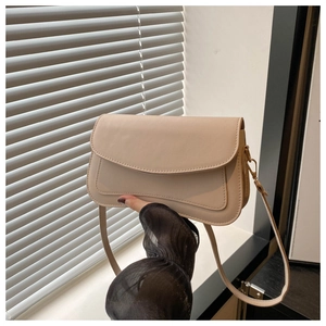 Detailed view of beige leather shoulder bag featuring fine stitching and gold hardware