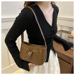 Detail of vintage brown leather shoulder bag with gold metal eyelets and drawstring accents