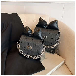Detailed view of gray fabric crossbody bag with black polka dots and oversized bow decor
