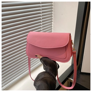 Detail of pink leather flap bag with fine stitching and golden metallic buckle