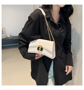 Détail d'un sac à bandoulière en cuir blanc cassé avec chaîne dorée et fermoir en T