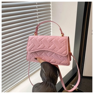 Detail of pink quilted handbag with heart embroidery and gold hardware clasp