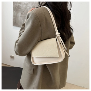 Nahaufnahme beige Schultertasche mit gewebter Klappe und Knotendetail am Riemen
