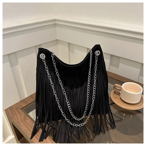 Detail of black suede-textured tote featuring long fringe and silver chain straps