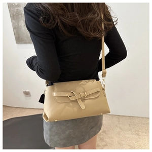Model view showing the back profile of a khaki crossbody bag with adjustable strap