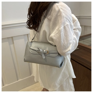 Detail of silver metallic leather crossbody bag with knot decor and gold buckle