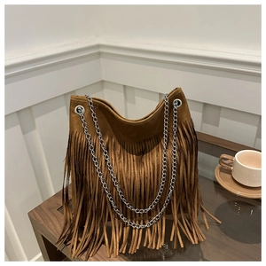 Close-up of a brown suede tote bag featuring long fringes and silver chain straps
