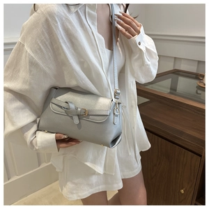 Detail of silver glitter crossbody bag with buckle flap and adjustable strap on a model