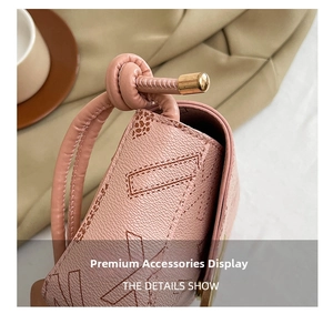 Detail view of pink pebbled leather shoulder bag with gold metal hardware and knotted strap