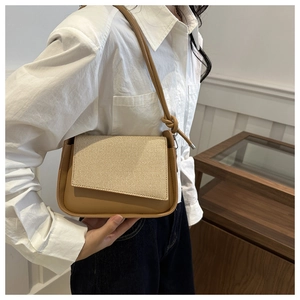 Detail der Retro-Schultertasche aus khakifarbenem Leder mit Stroh-Stoff-Patchwork