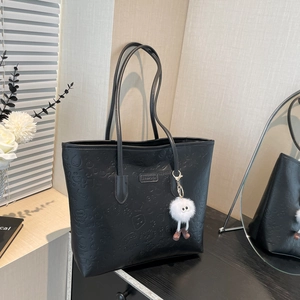 Chic black tote bag with embossed cartoon patterns and plush charm for daily commute