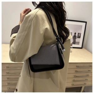Minimalistische schwarze Leder-Schultertasche mit grauem Twill in stilvollem Ambiente