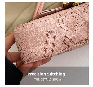 Macro shot of pink lychee leather texture and precise golden hardware stitching details