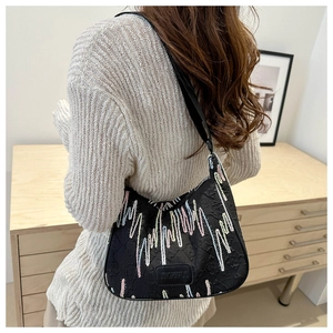 Detail of black nylon dumpling bag featuring colorful pulse embroidery on a female model