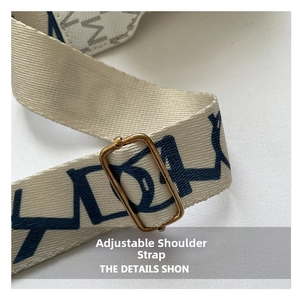 Detail of adjustable woven shoulder strap with blue abstract patterns and gold buckle