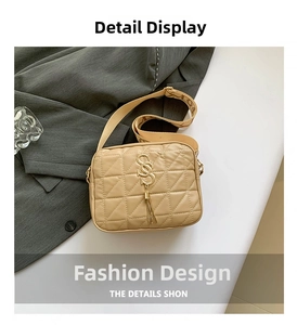 Détail du sac bandoulière beige matelassé avec logo S doré et gland métallique chic