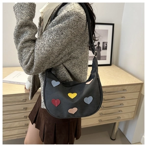 Detail of hobo shoulder bag featuring colorful heart patches and premium matte finish