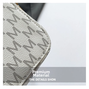 Close-up of pebble leather texture with signature MK monogram on a minimalist square bag