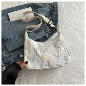 Detail of white fabric underarm bag with colored wave embroidery and F embossed pattern
