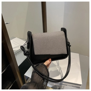 Details der schwarzen Leder-Schultertasche mit Webmuster-Klappe und Knotendesign