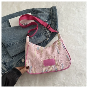 Close-up of pink fabric bag featuring wave embroidery and textured letter pattern